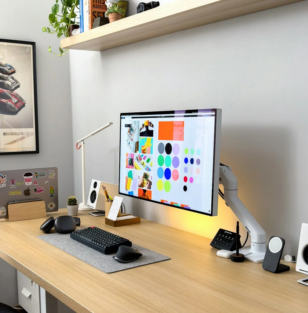A stylish workspace featuring a laptop and monitors displaying design software.
